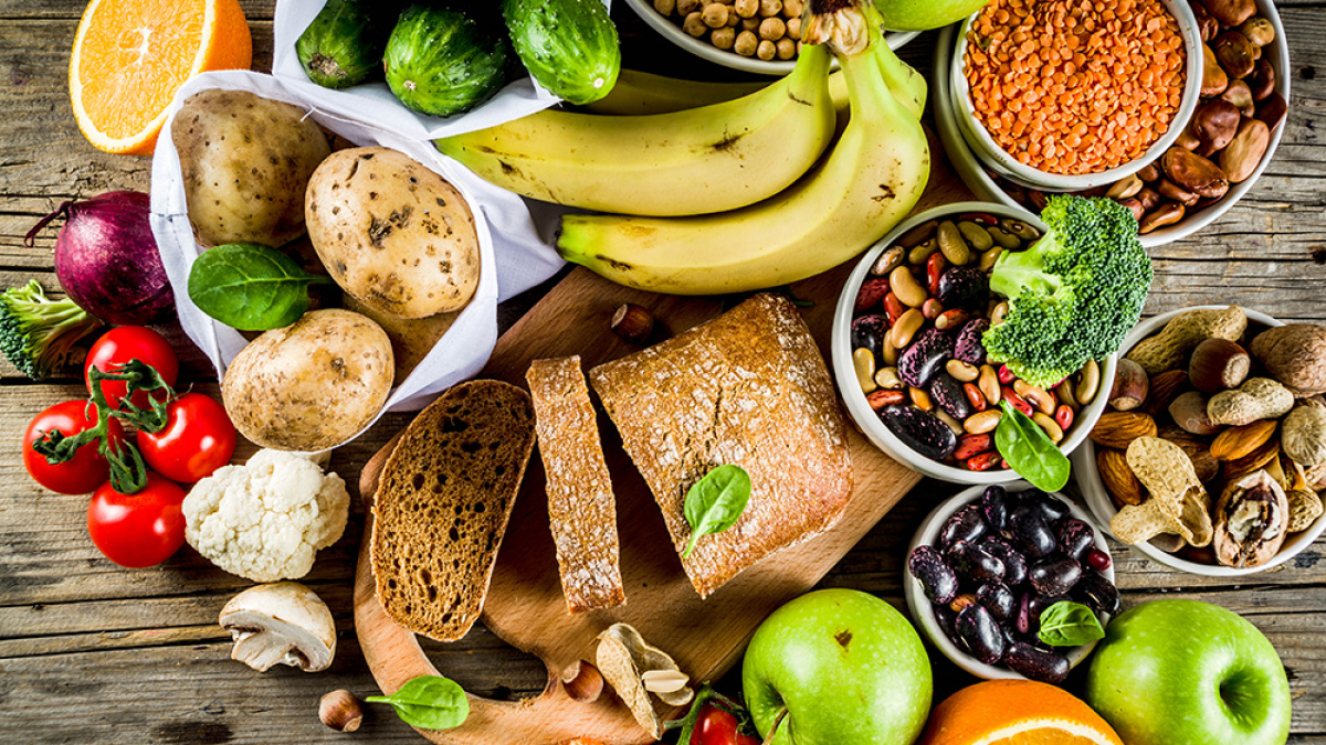 Healthy food. Selection of good carbohydrate sources, high fiber rich food. Low glycemic index diet. Fresh vegetables, fruits, cereals, legumes, nuts, greens. Wooden background copy space